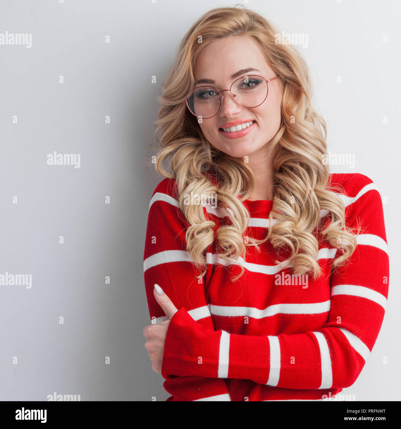 Portrait d'une belle jeune fille portant des lunettes et pull rayé rouge  sur fond blanc Photo Stock - Alamy