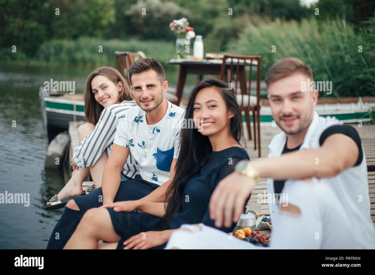 Groupe de professionnels jeunes amis se détendre sur la jetée de la rivière. Concept de vacances d'été Banque D'Images