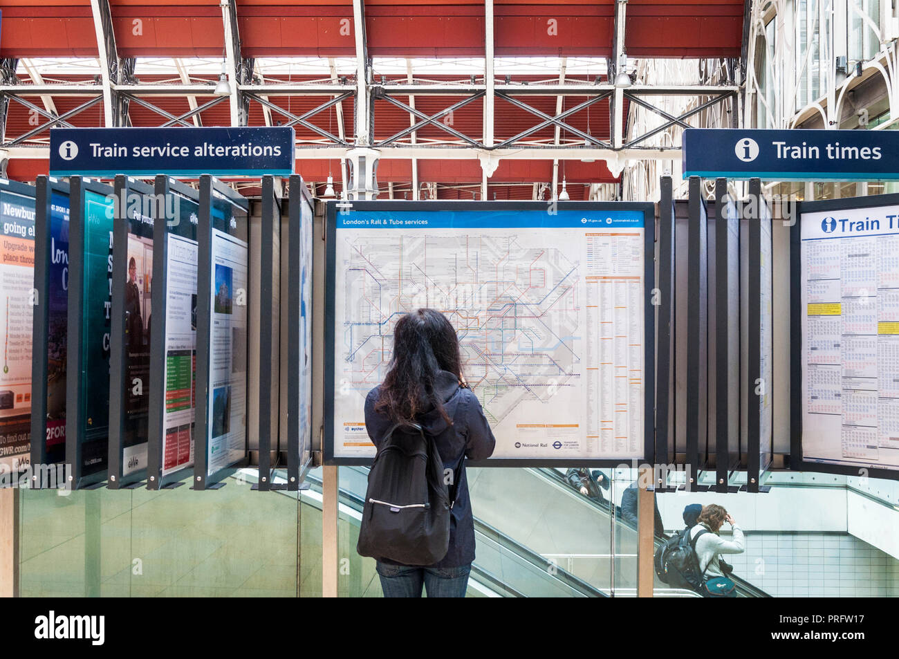 La gare de Paddington, Londres, Royaume-Uni. Passagère se penche sur la carte dans le grand hall. Banque D'Images
