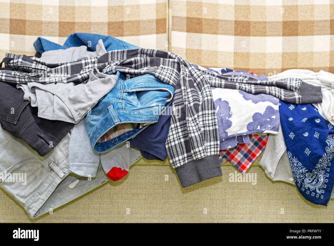 Beaucoup de vêtements froissés lying on sofa Banque D'Images