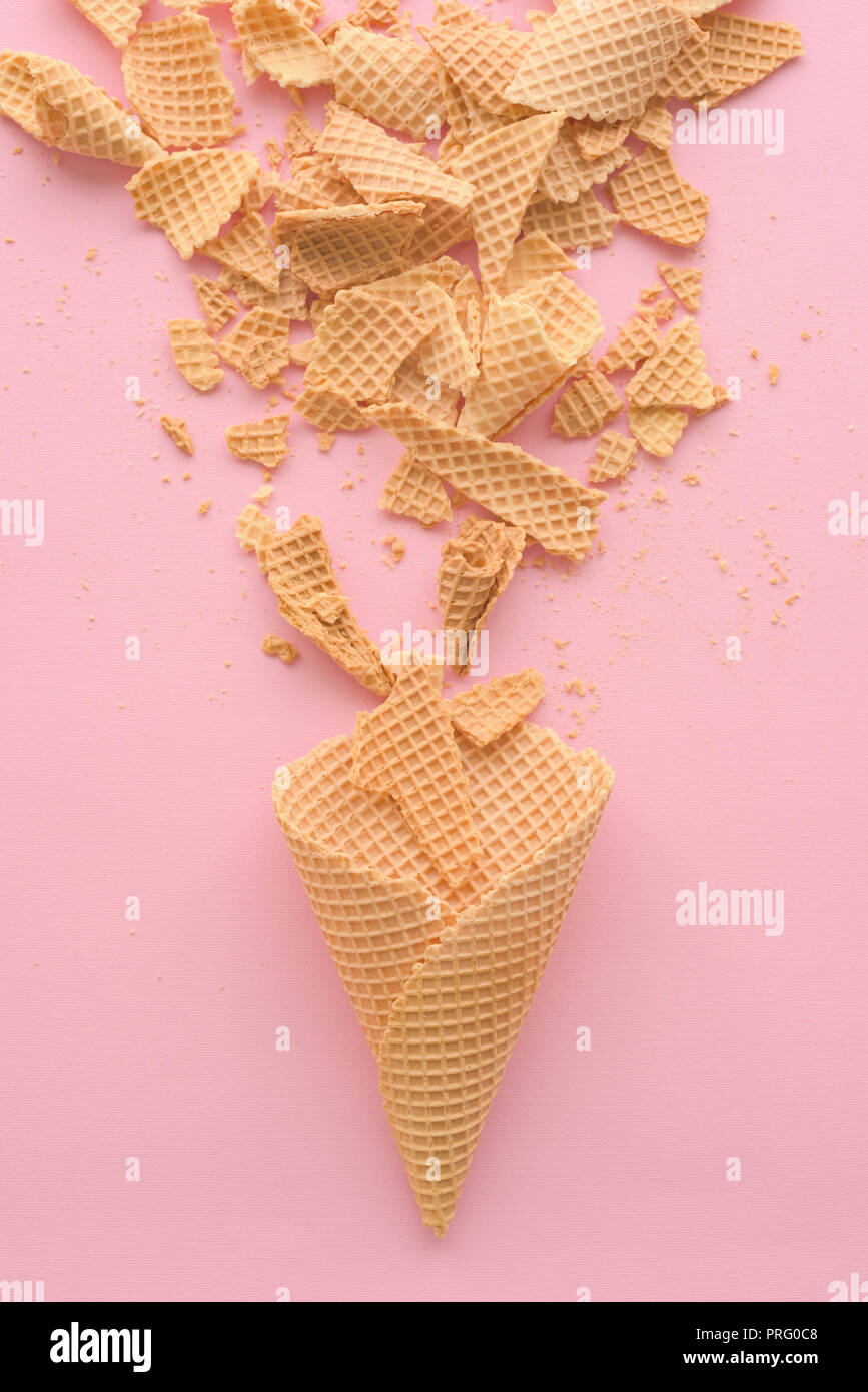 Ice cream cones gaufre sur fond rose pastel, vue du dessus télévision moderne laïcs composition minimale Banque D'Images