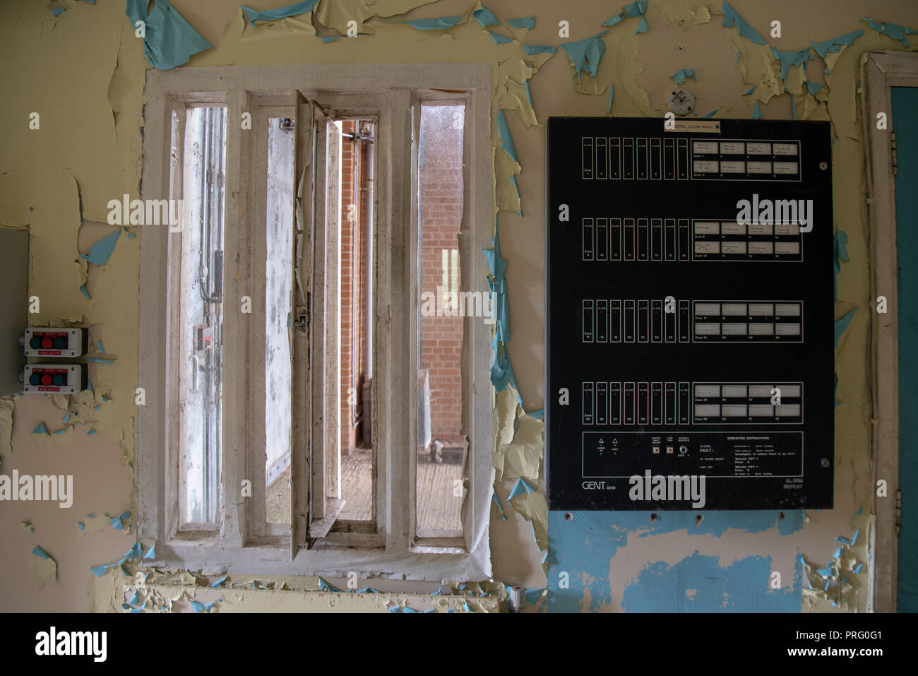 L'intérieur de la fenêtre de l'entrée de la garde d'une prison abandonnée, avec une centrale d'alarme. Banque D'Images