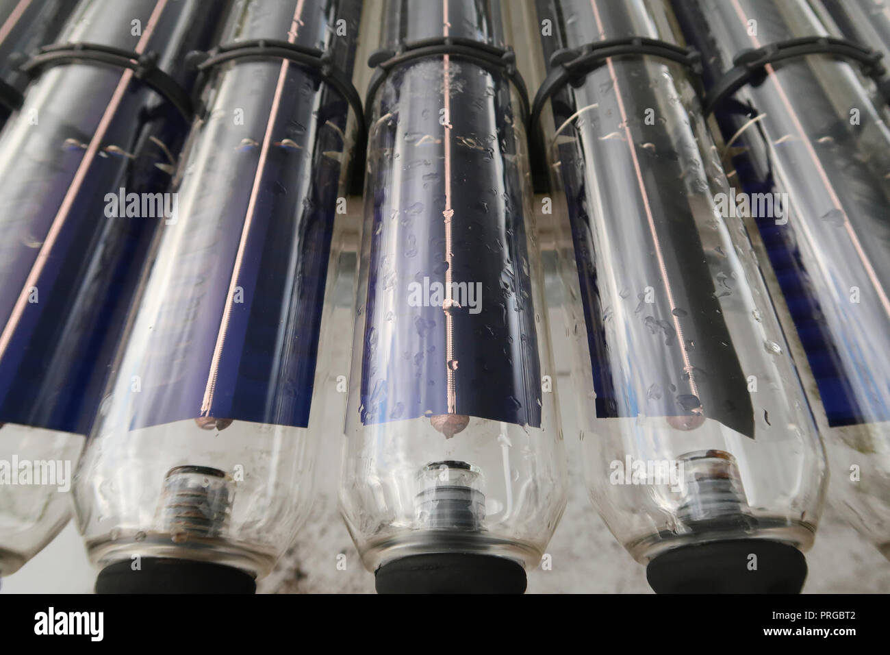 Les tubes de chauffage solaire de l'eau sur le toit du bâtiment Banque D'Images