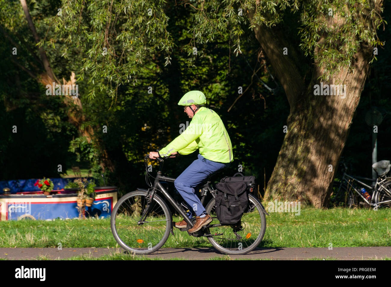 Un homme âgé cycliste vélo sur un chemin le long d'une journée d'été, Cambridge, Royaume-Uni Banque D'Images