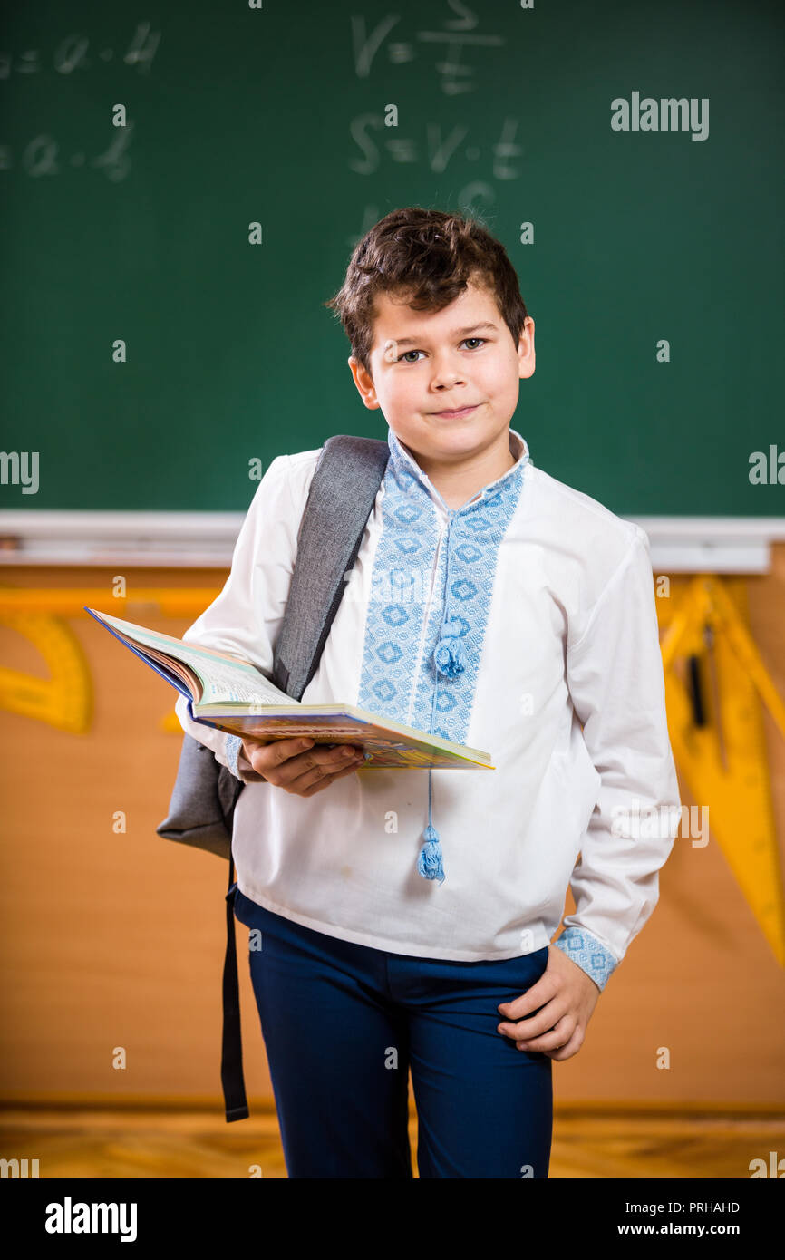 Portrait d'un écolier. Les jeunes de 10 ans Young boy posing dans une  classe d'école, debout contre un conseil scolaire. Collège Thème Photo  Stock - Alamy