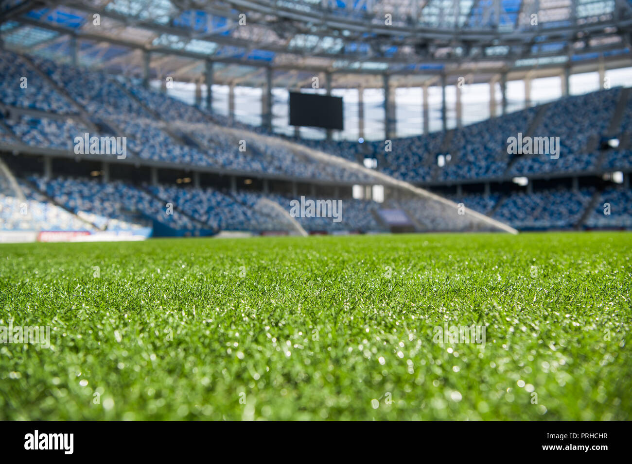 L'herbe sur stadium à la lumière du soleil. Libre de terrain de football. L'herbe du stade humide dans la lumière du matin au cours de l'arrosage l'irrigation. Macro Close up de soccer ou de football champ. Green grass field background. Stade vide Banque D'Images