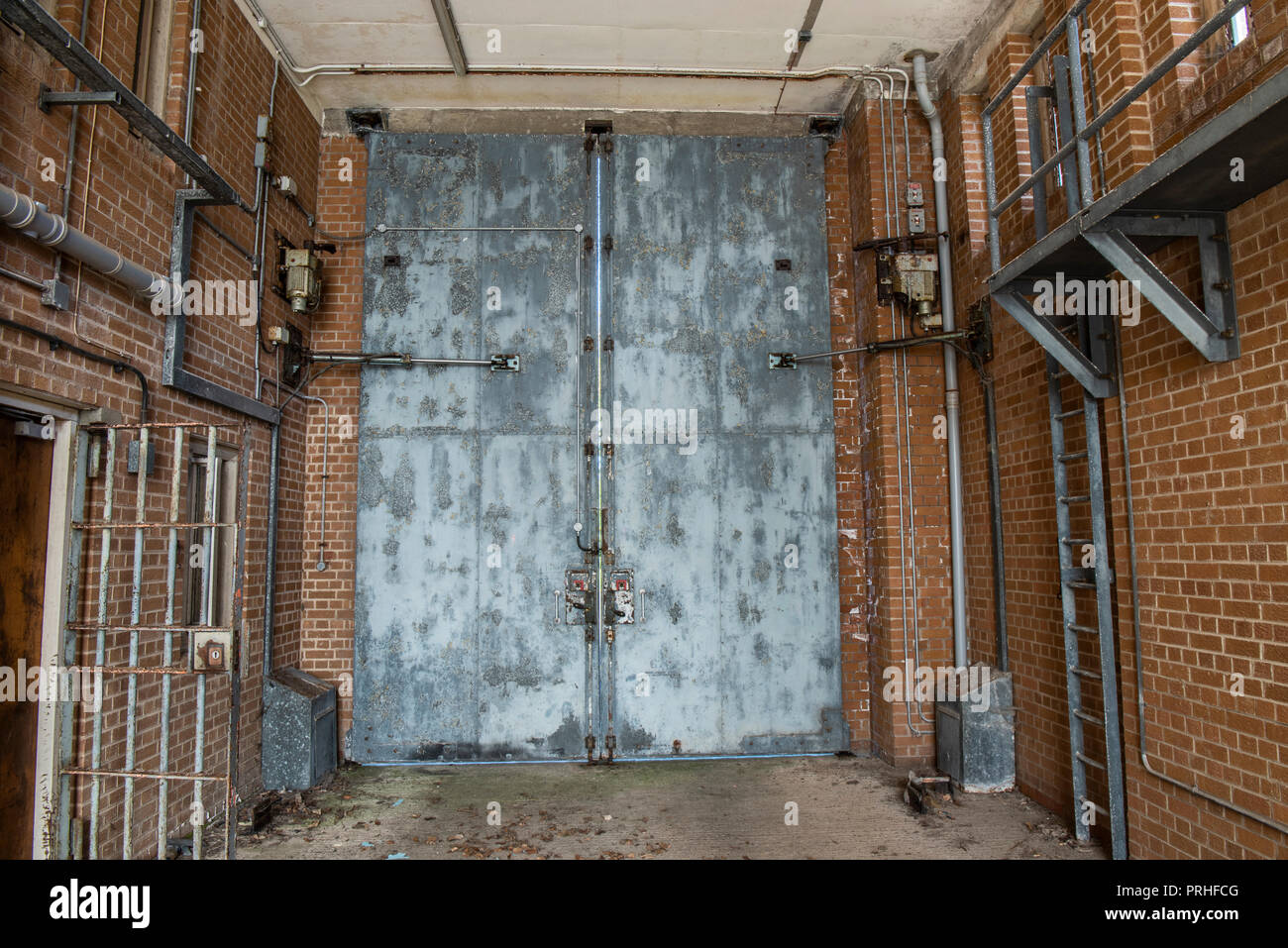 Fonctionnement hydraulique des portes d'acier à l'intérieur du véhicule baie d'une prison. Banque D'Images