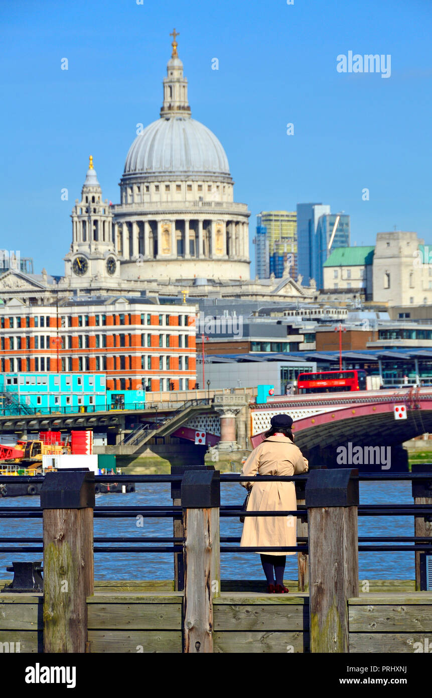 Femme regardant vers la Cathédrale St Paul à partir de l'un des quais en bois sur Gabriel's Beach, South Bank, Londres, Angleterre, Royaume-Uni. Banque D'Images