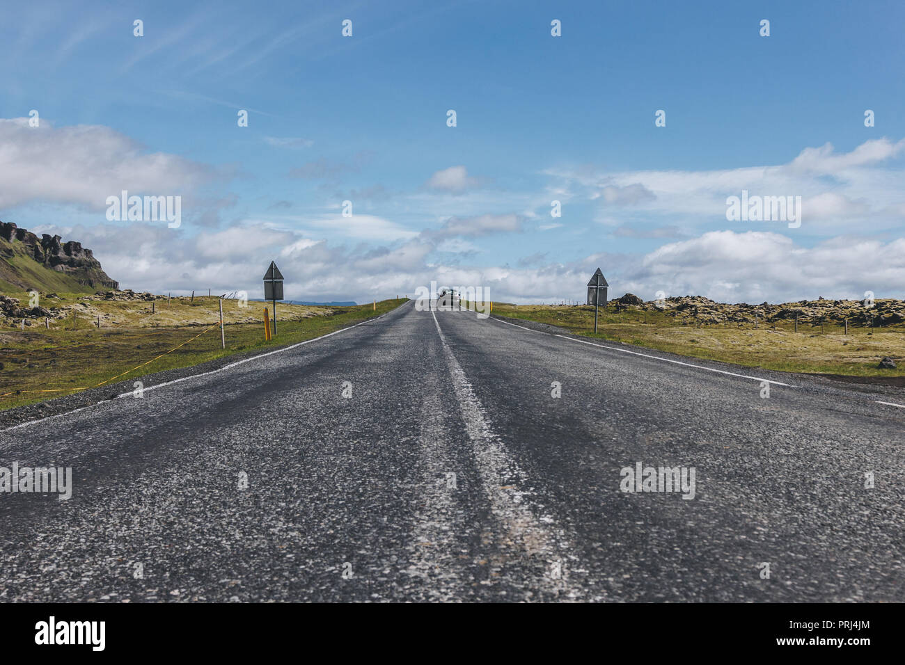 Route avec voiture à highlands sous blue cloudy sky en Islande Banque D'Images