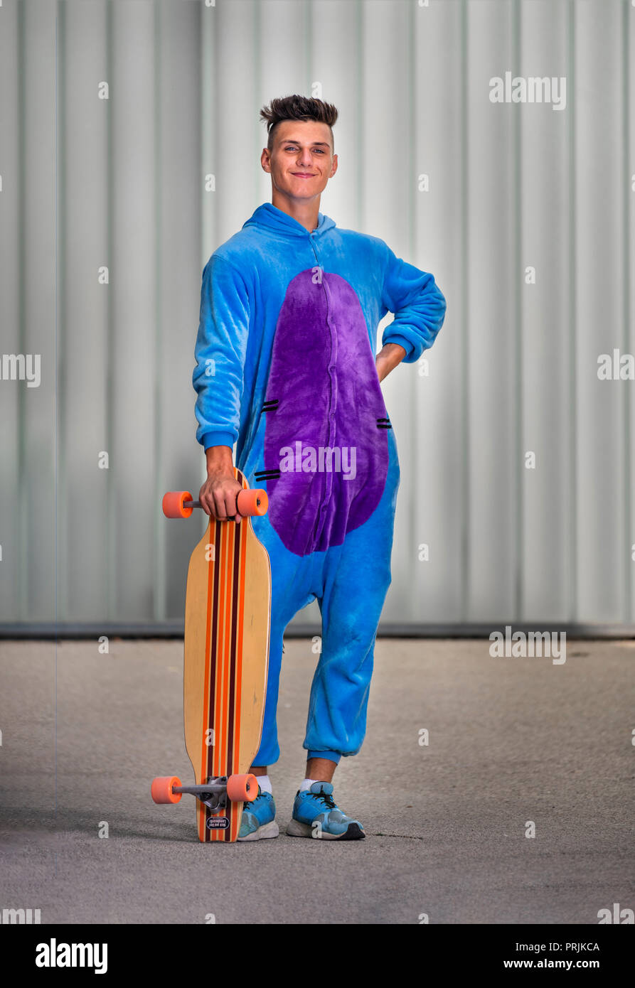 Adolescent, 17 ans, portant un onepiece avec longboard, Allemagne Banque D'Images