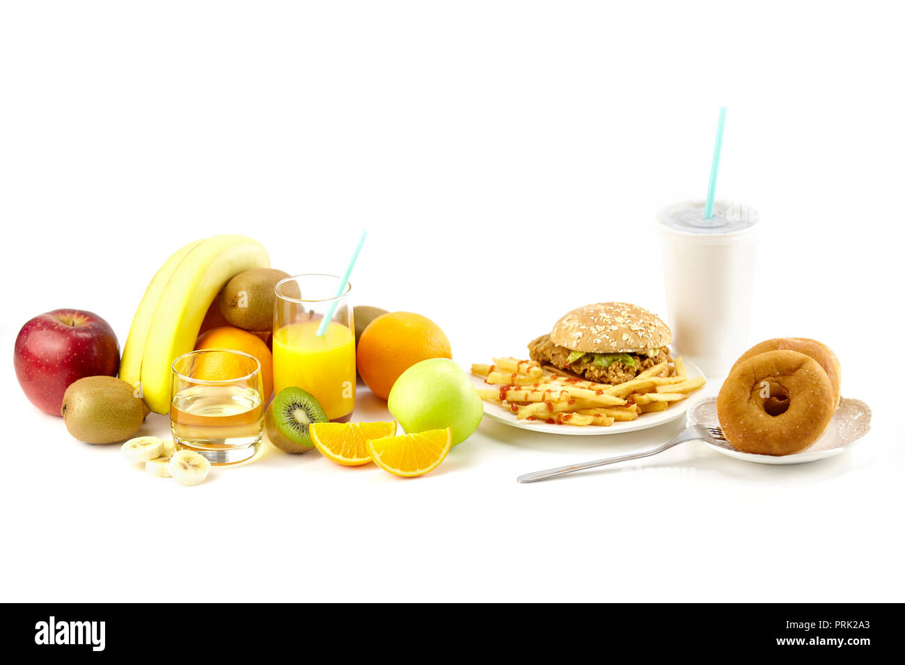Un assortiment de fruits frais, jus, Hamberger, frites, beignets et la boisson isolé sur fond blanc. Banque D'Images