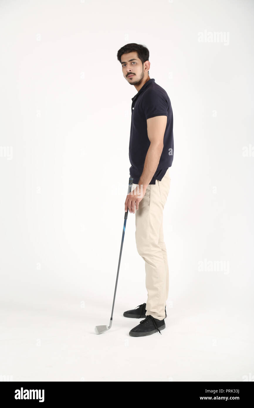 Jeune garçon debout sur le plancher avec bâton de golf à la main. Isolé sur fond blanc. Banque D'Images