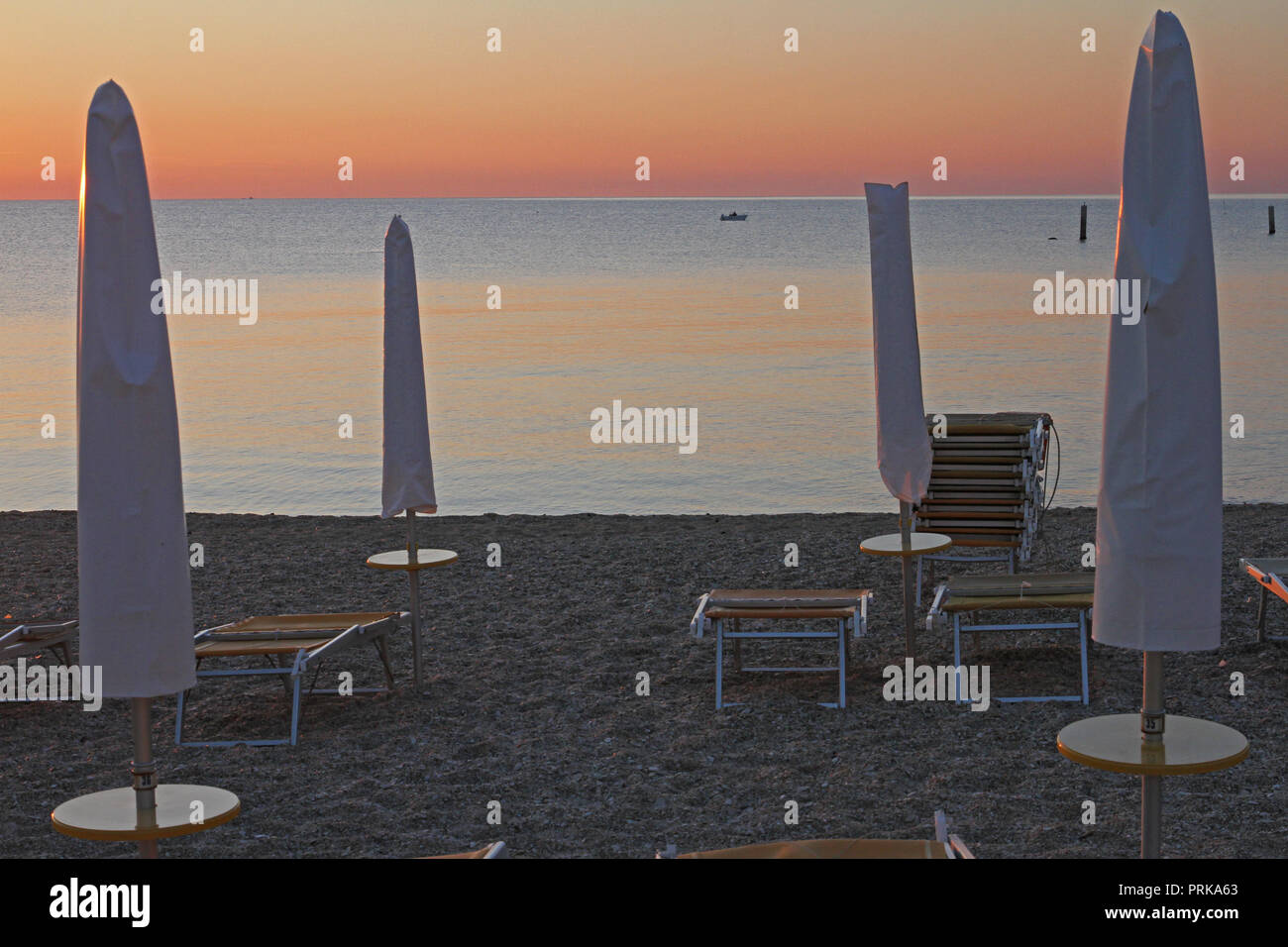 Le lever du soleil sur la mer Adriatique, à la fin de l'été sur la Riviera italienne, près de Porto Recanati et Numana à Ancône avec bateaux de pêche dans la distance Banque D'Images