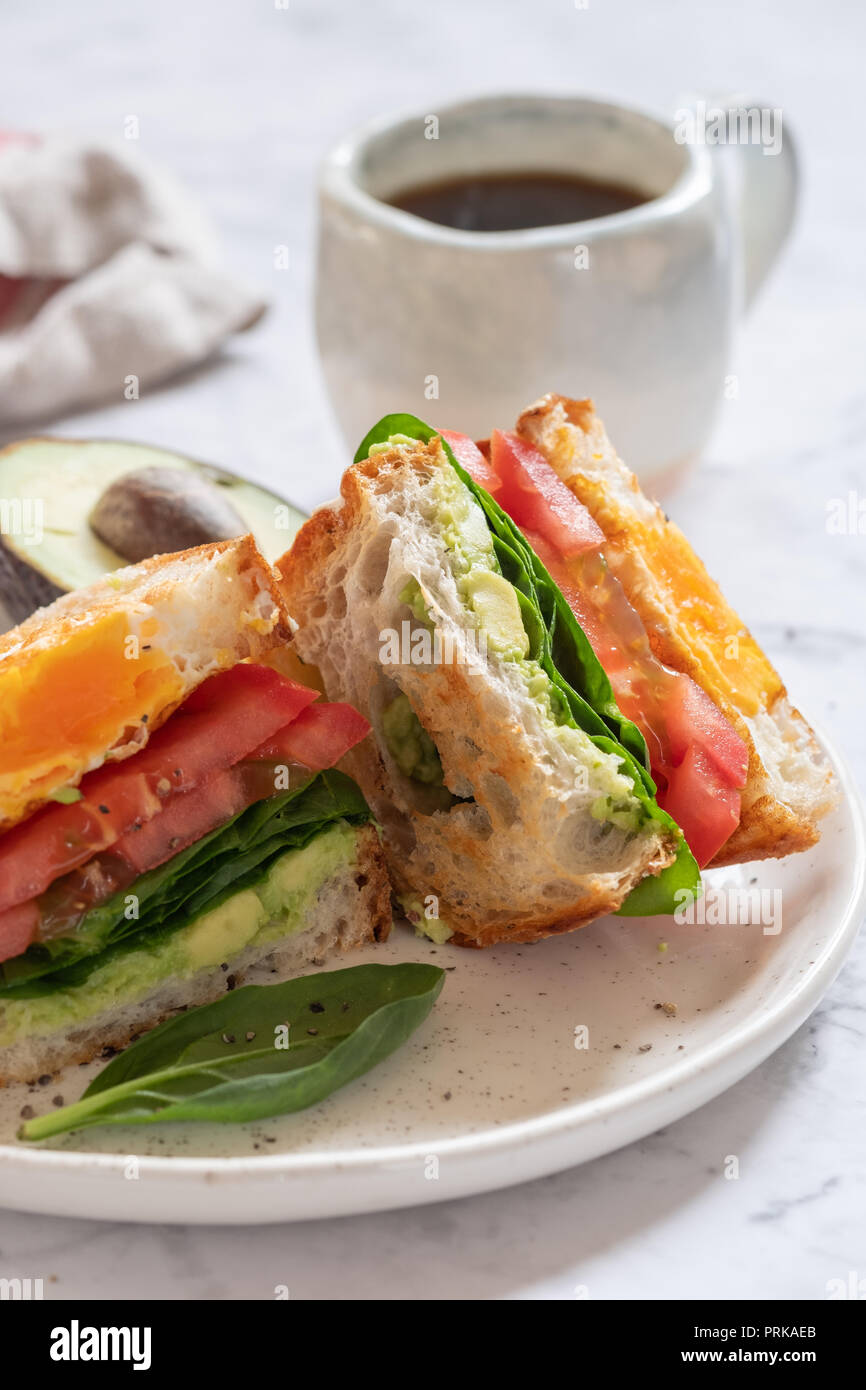 Sandwich œuf dans un trou avec de l'avocat, Épinards et tomates Banque D'Images