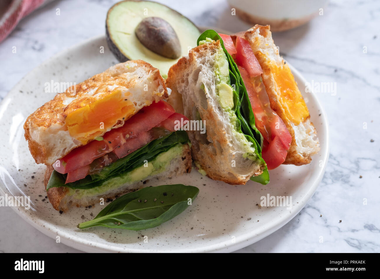 Sandwich œuf dans un trou avec de l'avocat, Épinards et tomates Banque D'Images