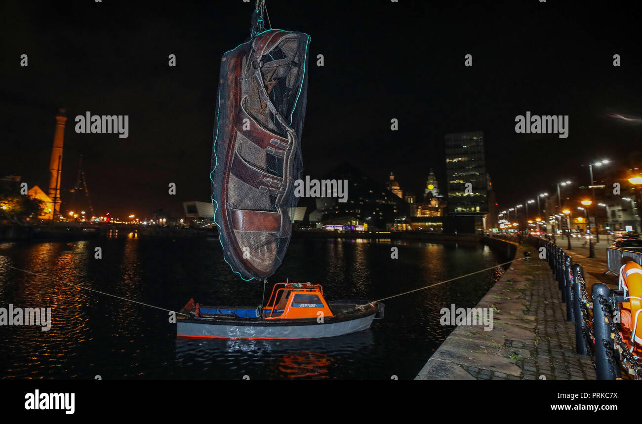Un géant sandale est suspendu au-dessus d'un petit bateau dans le cadre de  la Royal de Luxe spectaculaire géants, Liverpool's Dream, qui commence le  vendredi à Liverpool et le Wirral Photo Stock -