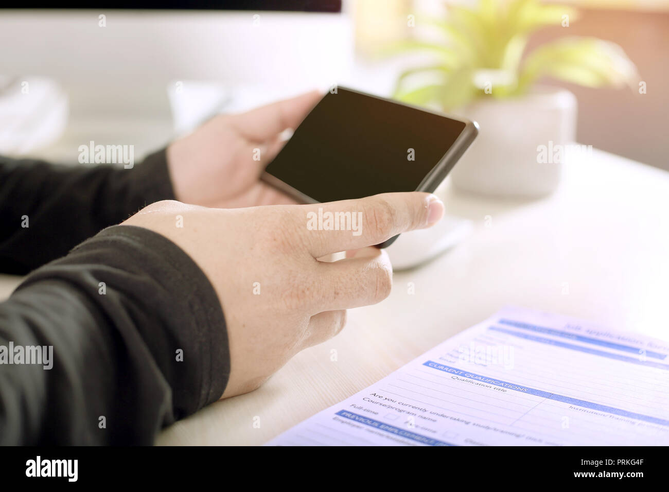 Man holding phone dans la main avec papier. Banque D'Images