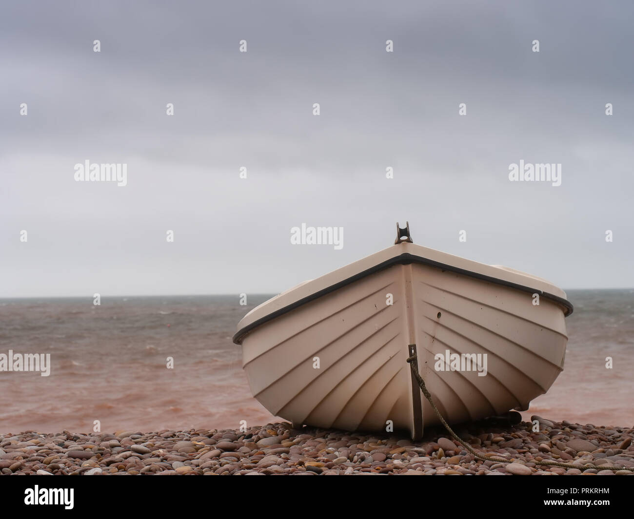 Petit bateau sur la plage de galets, est échoué. L'hiver. Banque D'Images