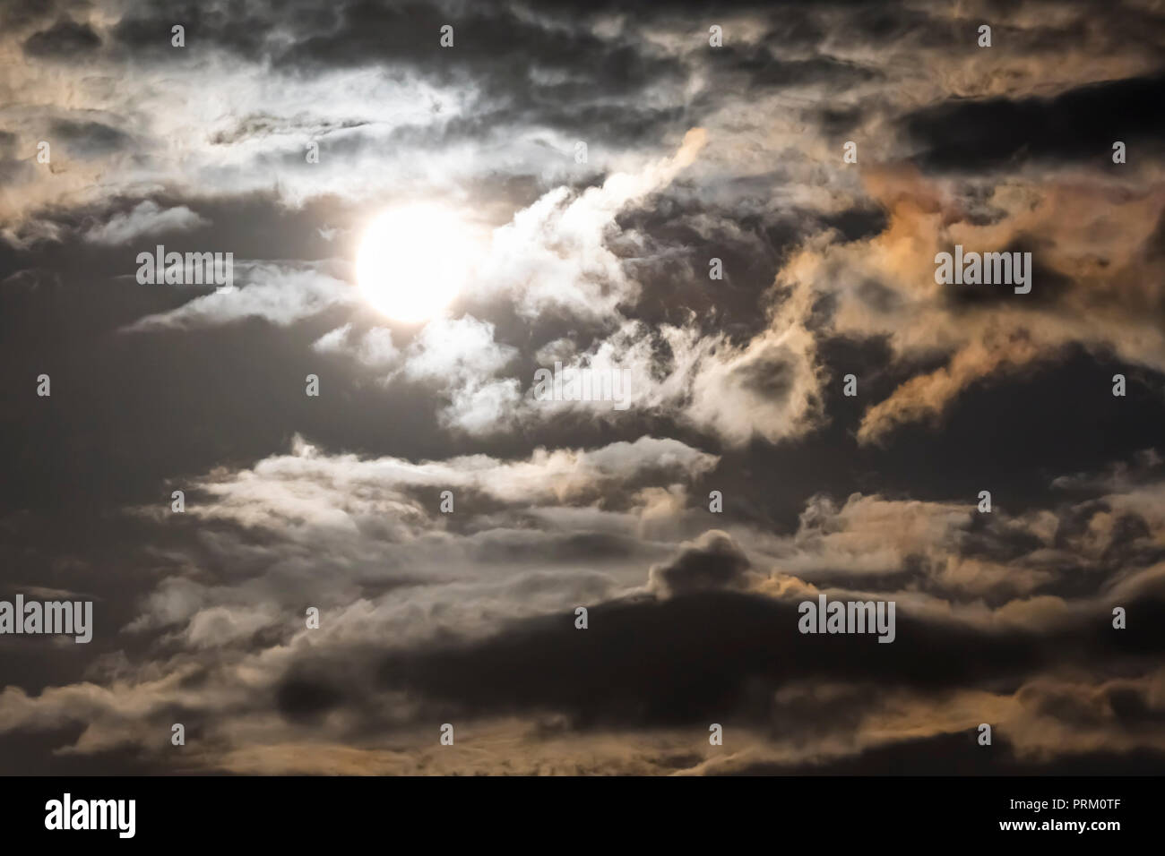 Pleine lune surexposée, et très lumineux dans un ciel nuageux, la nuit moody sky. Banque D'Images