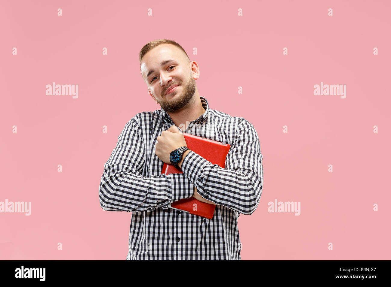 Businessman hugging ordinateur portable. L'amour à computer concept. Attractive male avant mi-longueur à la mode, portrait studio rose backgroud. Jeune homme barbu émotionnelle. Les émotions humaines, l'expression faciale concept. Banque D'Images