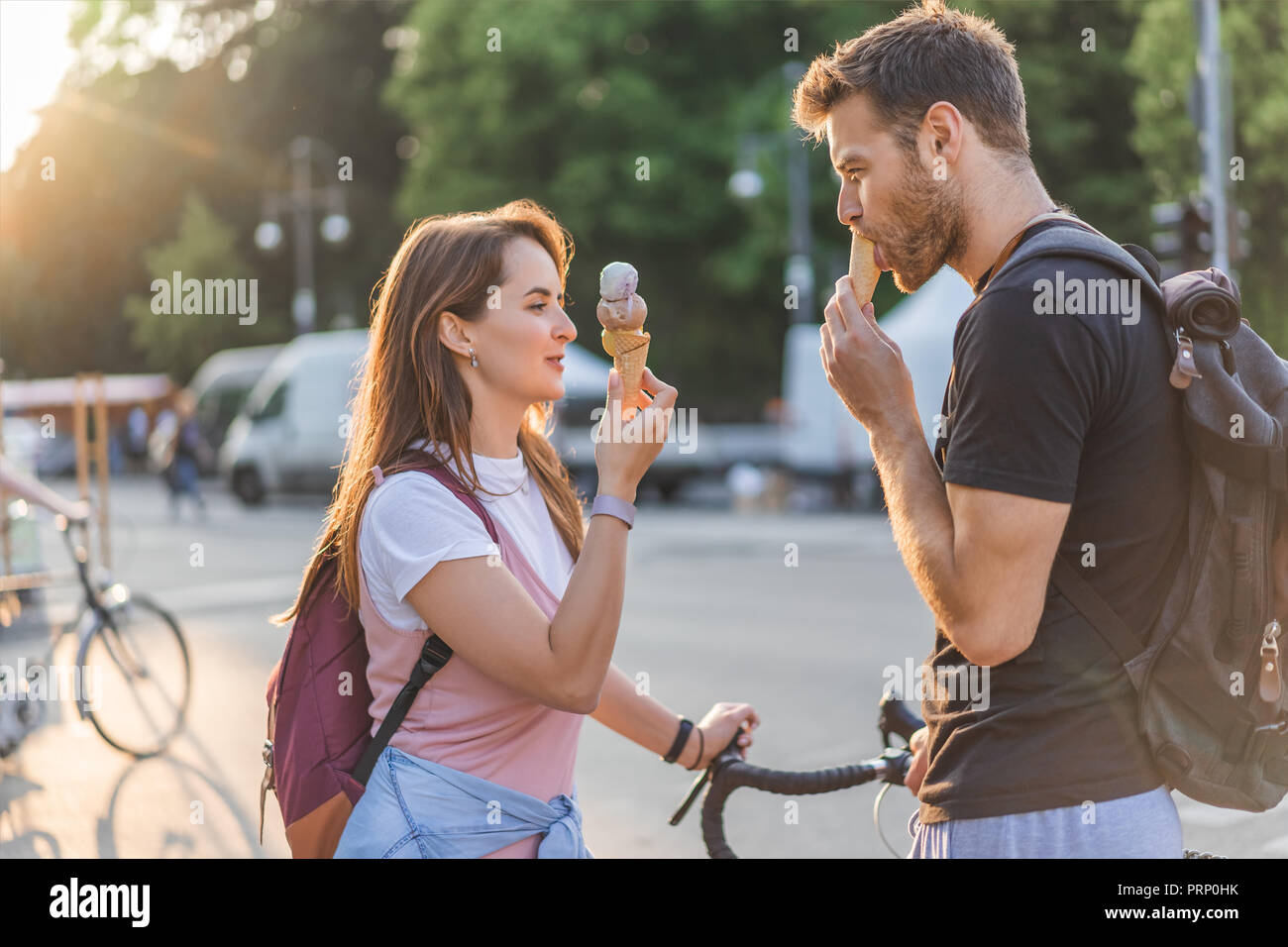 Side view of young woman eating ice cream au city street Banque D'Images