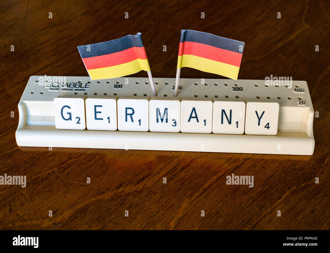 L'orthographe des lettres scrabble SCRABBLE en Allemagne bac avec drapeau allemand sur fond d'acajou sombre Banque D'Images