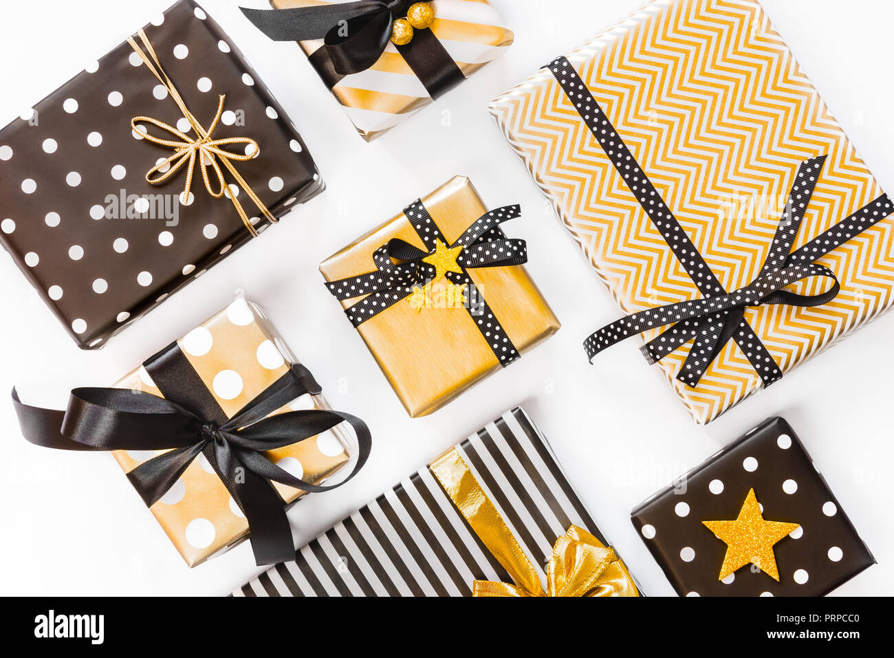 Vue de dessus de boîtes-cadeaux dans différents coloris noir, blanc et doré. Mise à plat. Un concept de Noël, Nouvel An, fête l'événement. Banque D'Images