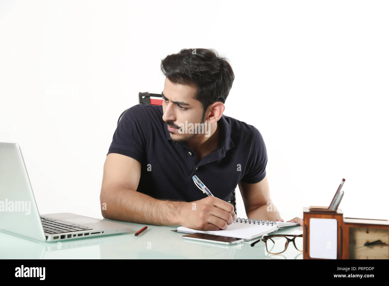 Jeune garçon est à la recherche de travail de bureau sur ordinateur portable et l'écriture sur ordinateur portable. Isolé sur fond blanc. Banque D'Images