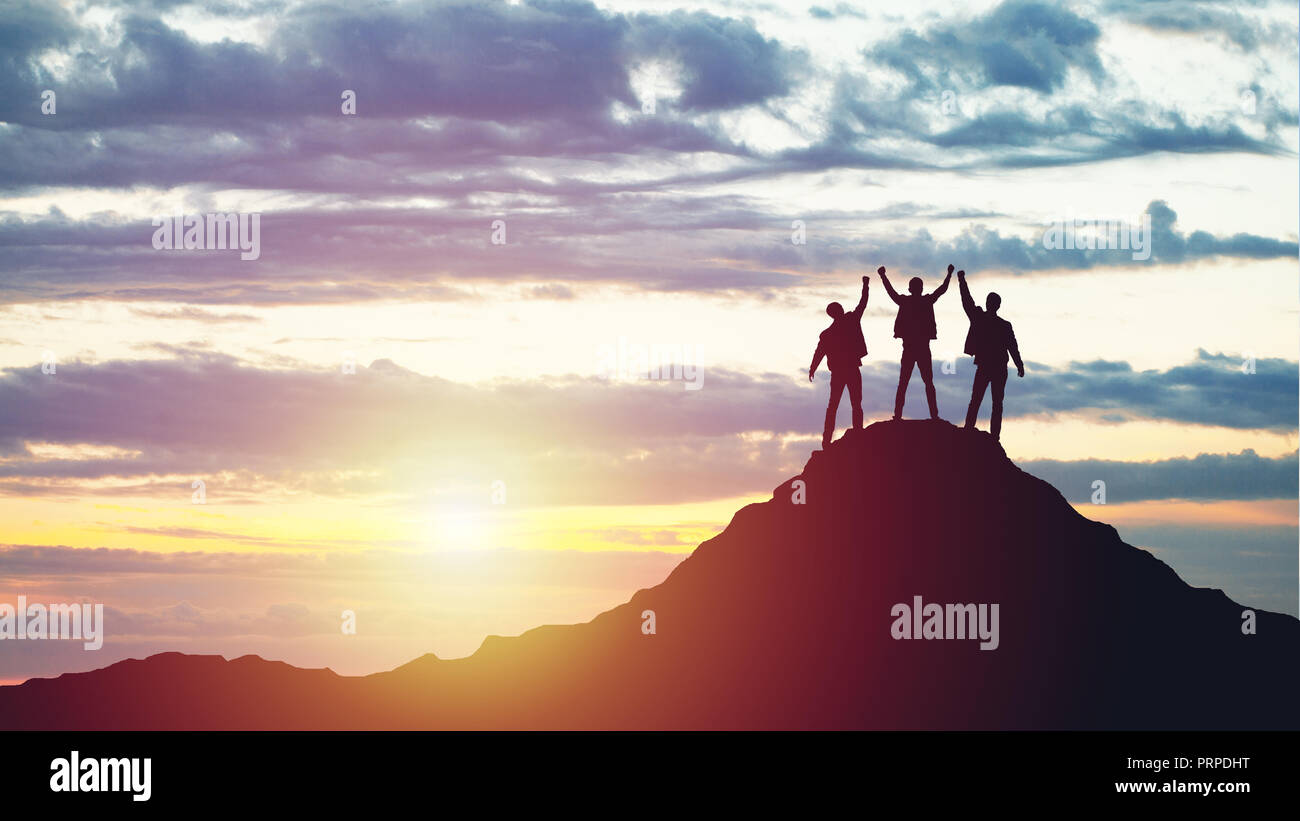 Silhouettes d'heureux trois personnes au sommet d'une montagne Banque D'Images