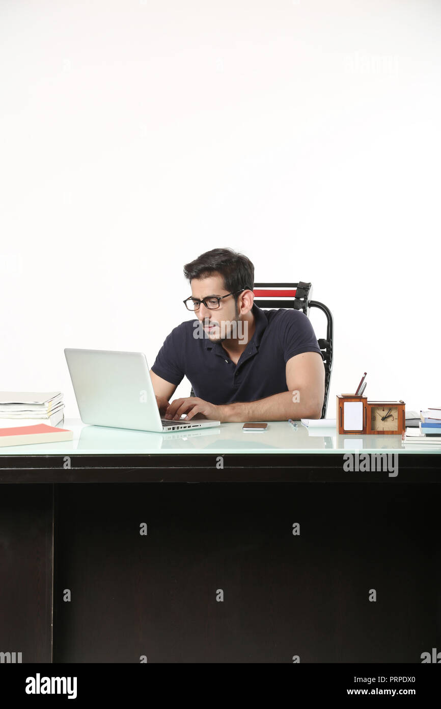 L'homme travaille dans un ordinateur portable avec le port de lunettes noires. isolé sur fond blanc. Banque D'Images