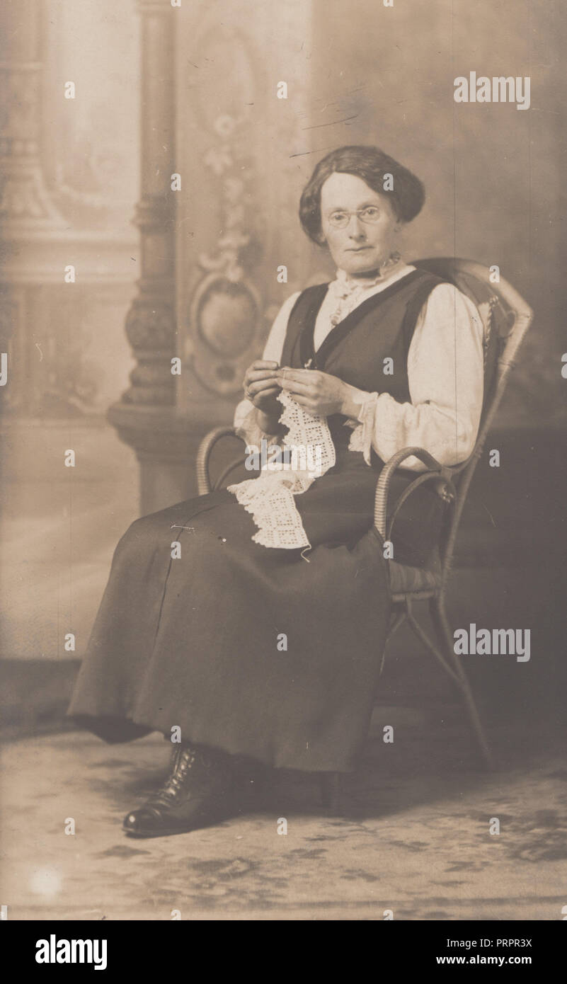 * Vintage Photo d'une vieille dame s'assit sur une chaise le tricot ou la couture Banque D'Images