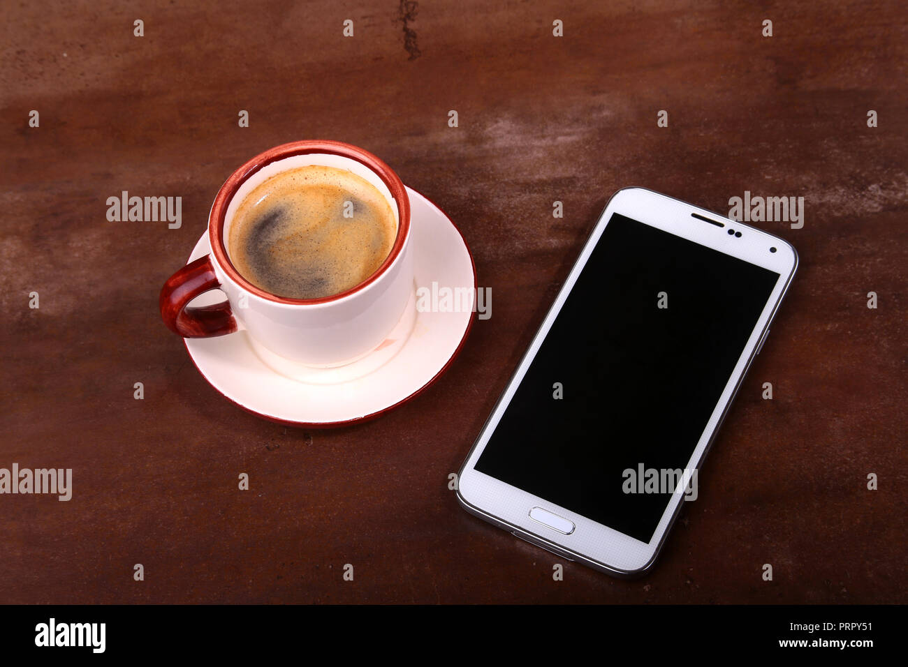 Tasse à café et smartphone sur table en bois. Vue de dessus Banque D'Images