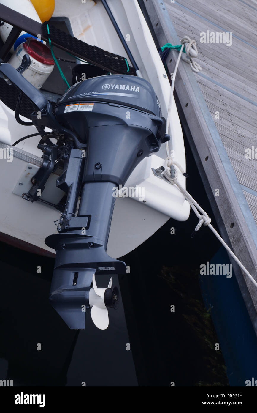 Moteur hors-bord Yamaha, sorti de l'eau, joint au petit bateau amarré au port de Lochinver, Ecosse Banque D'Images