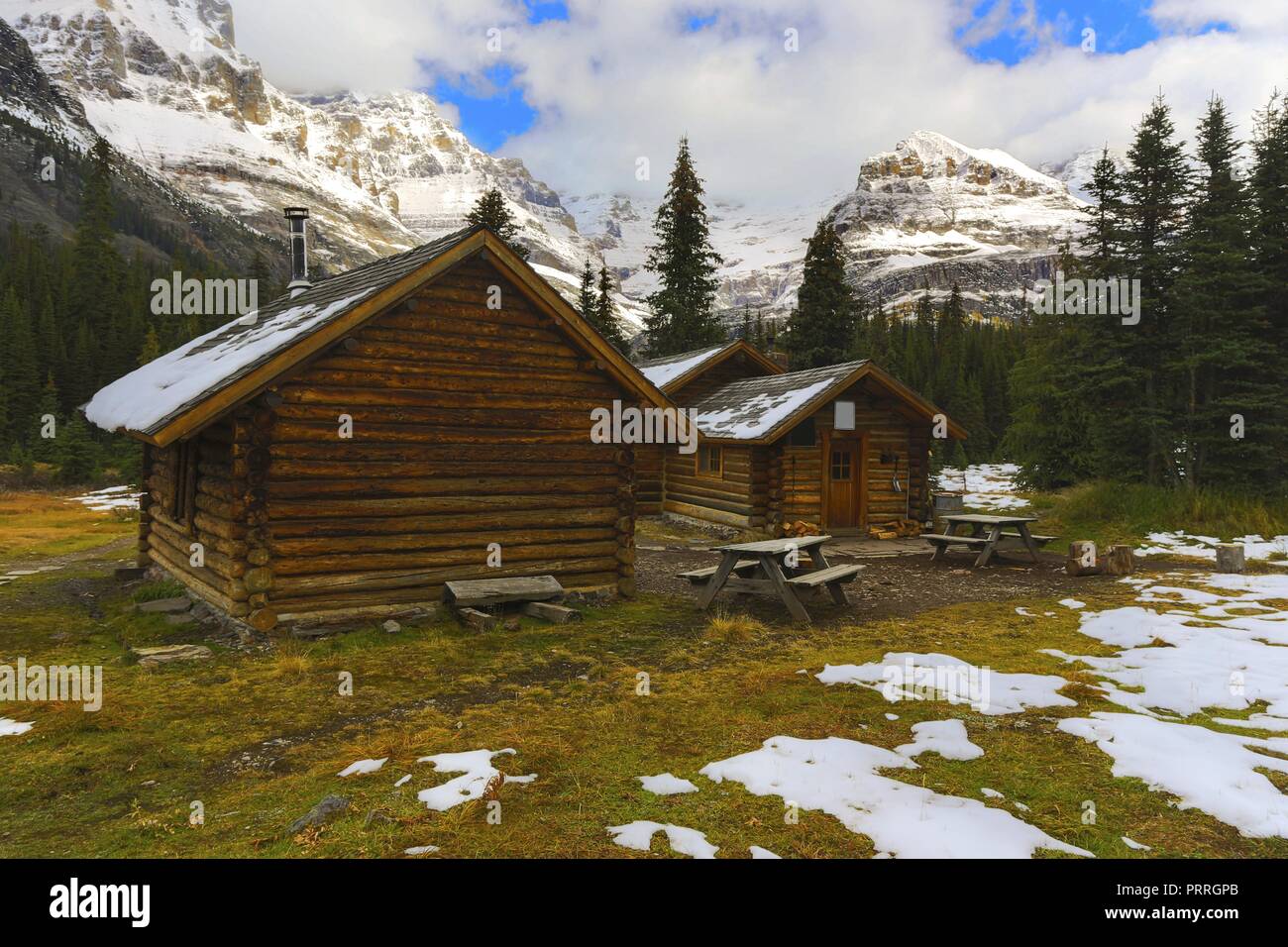 Alpine Club of Canada Wilderness Log Cabin refuge rustique et sommets enneigés éloignés près du lac O’Hara dans le parc national Yoho Banque D'Images