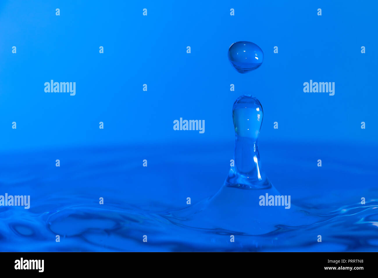 Des gouttelettes d'eau colorée de rebondir sur l'eau Banque D'Images