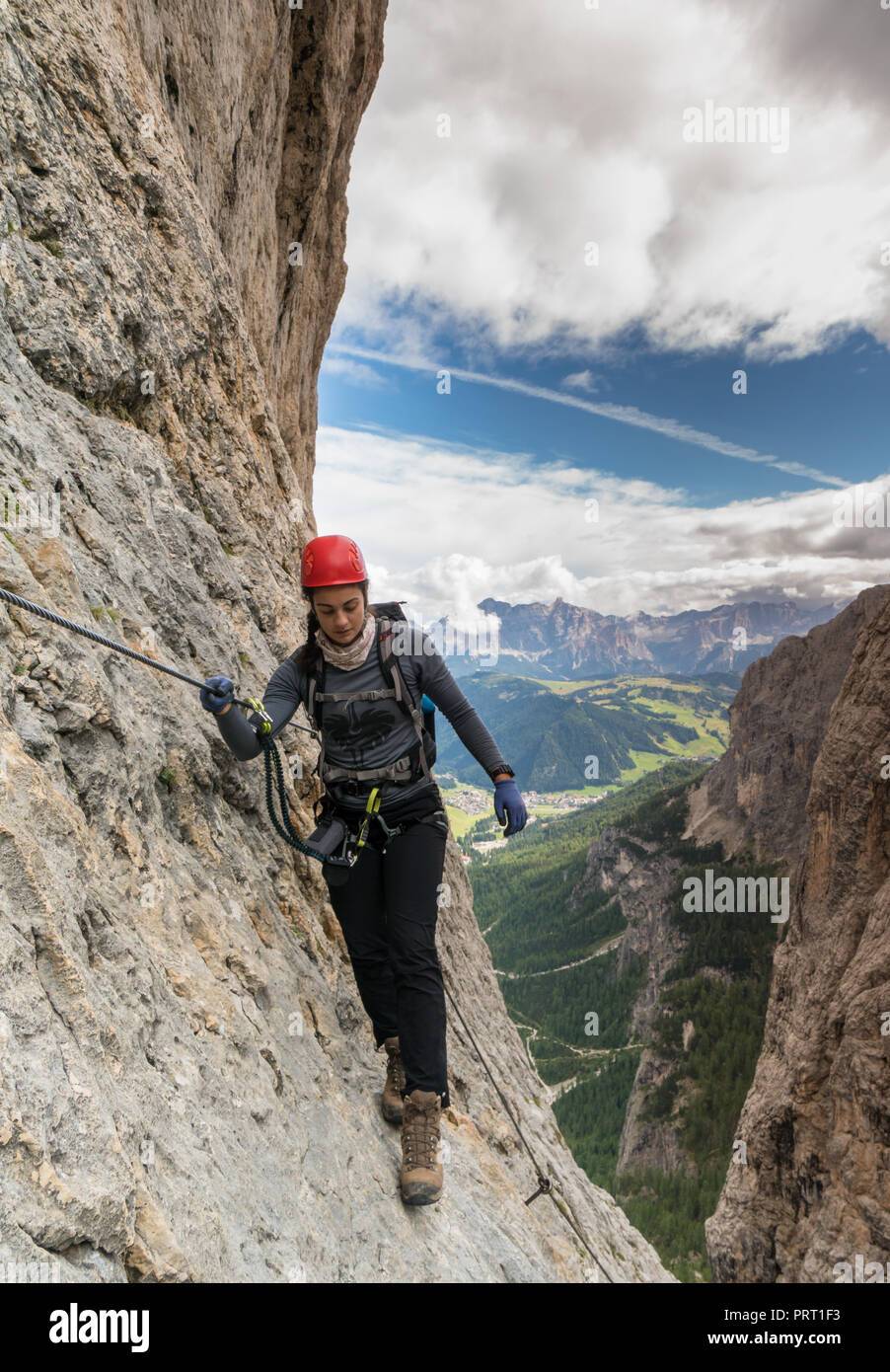 Jolie jeune femme d'alpiniste sur une via ferrata dans les Dolomites en Alta Badia Banque D'Images