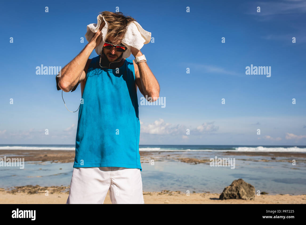 Sportif en sueur avec serviette debout en mer Banque D'Images
