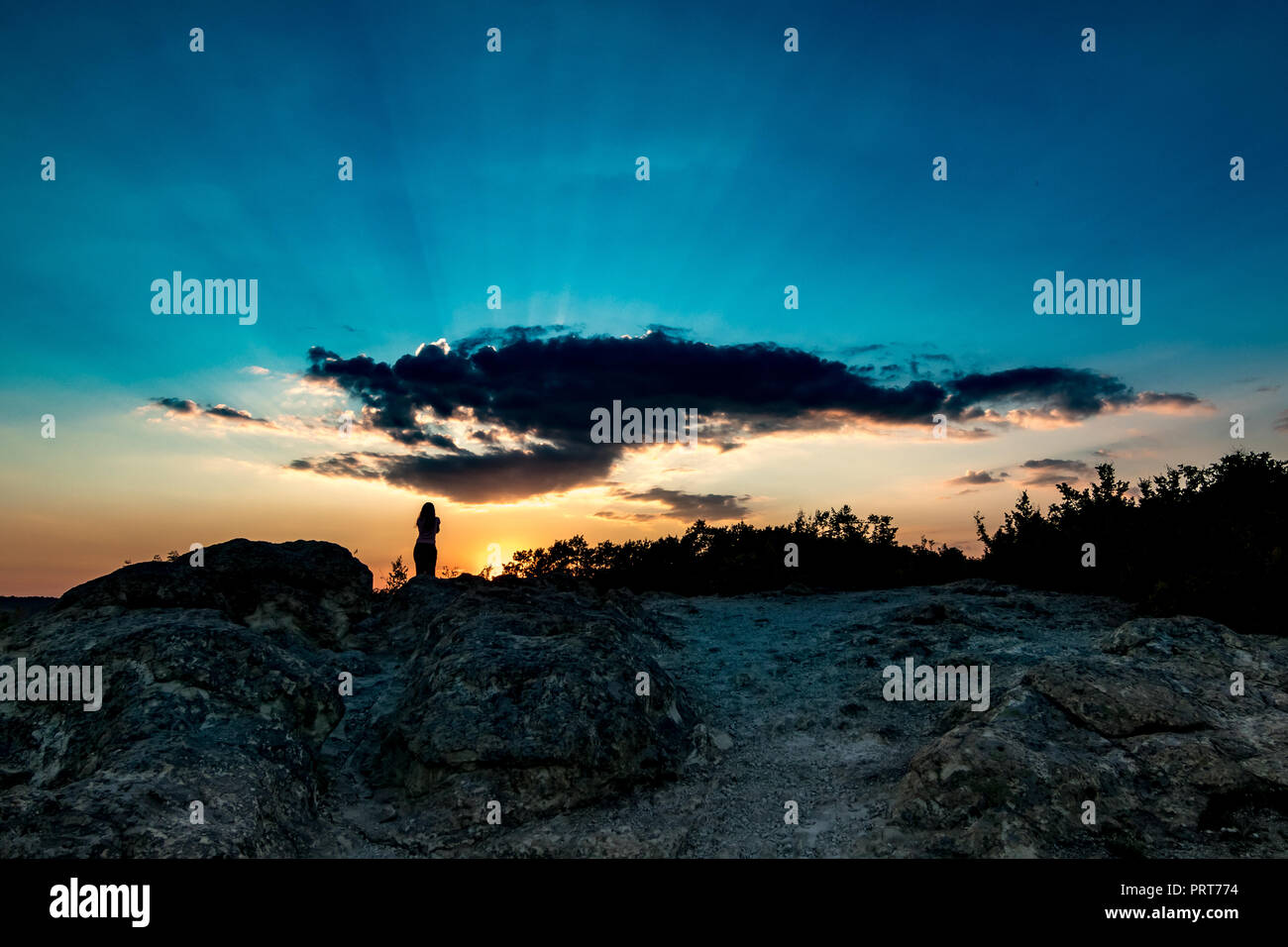 Silhouette féminine méconnaissable au soleil colorés avec les rayons du soleil contre le soleil près de la pierre de champignons phénomène naturel dans le sud de la Bulgarie, près de la ville de Kardzhali Banque D'Images