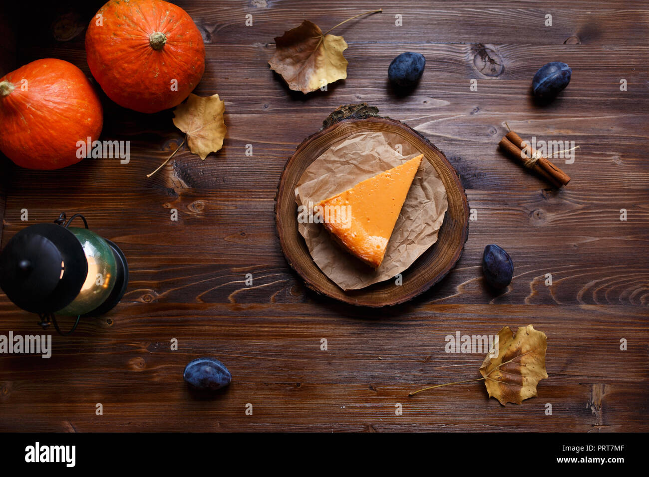 Gâteau au fromage à la citrouille cuite, à la maison, de citrouilles, de prune, de vanille , feuillage sur un tableau noir en bois. L'automne et l'hiver concept confortable. Et Menu restaurant conce Banque D'Images