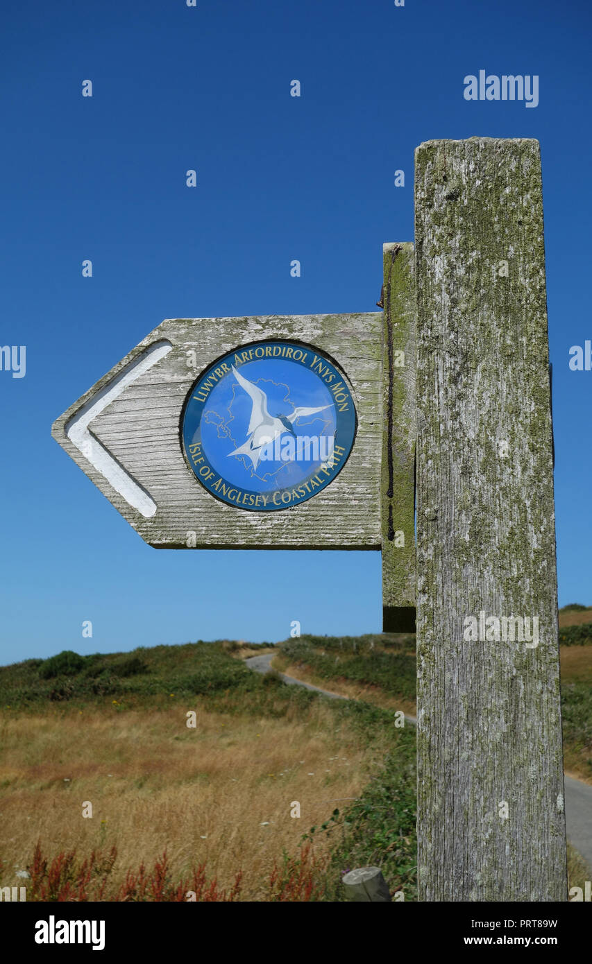 Panneau en bois pour l'île d'Anglesey Sentier Littoral près du village de pêcheurs de Cemaes, Pays de Galles, Royaume-Uni. Banque D'Images