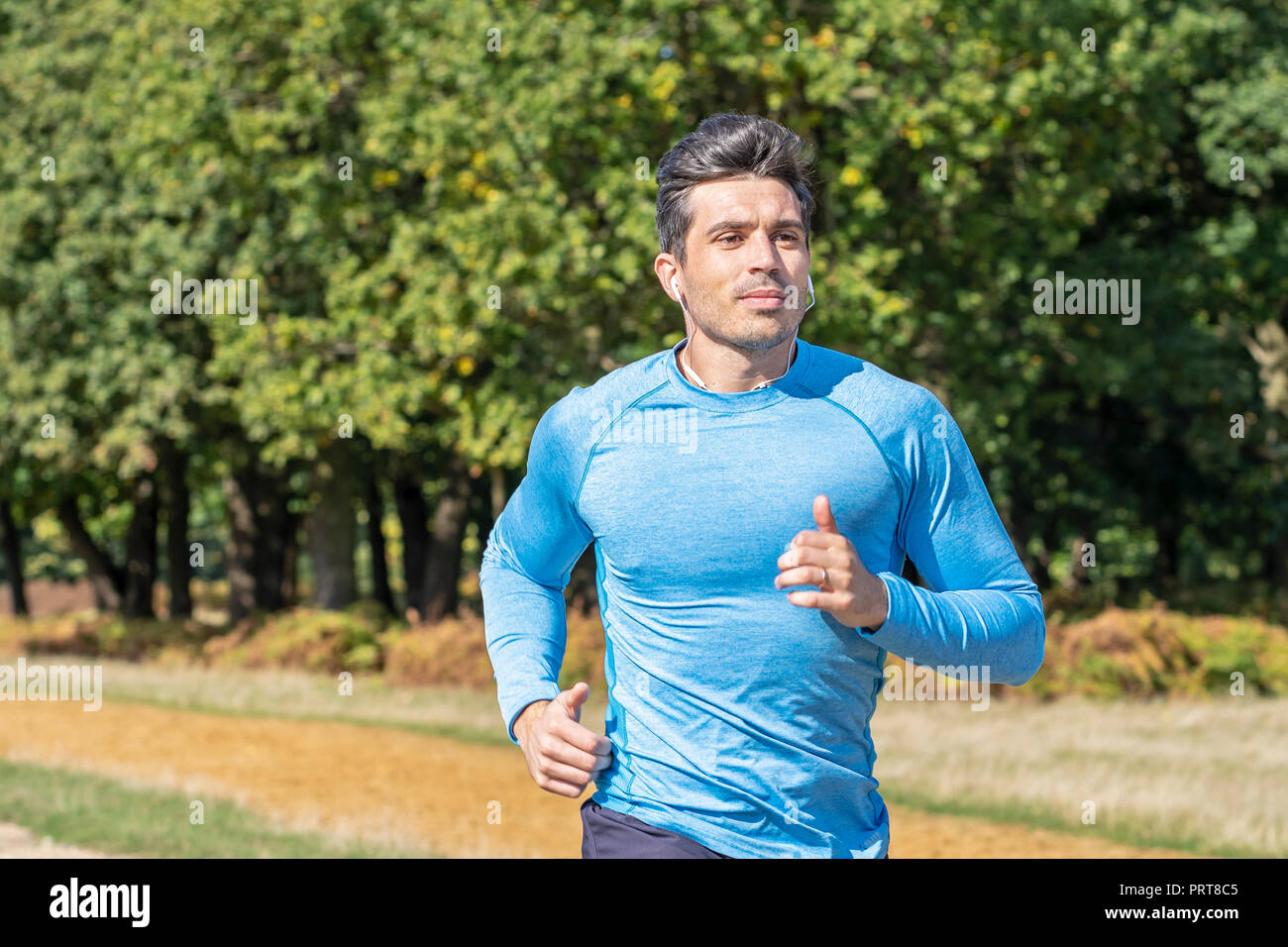 Homme séduisant du jogging dans le parc. L'Entraîneur personnel d'exécution et de faire de l'exercice Banque D'Images