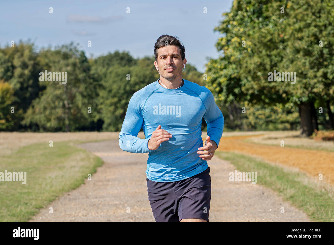 Homme séduisant du jogging dans le parc. L'Entraîneur personnel d'exécution et de faire de l'exercice Banque D'Images