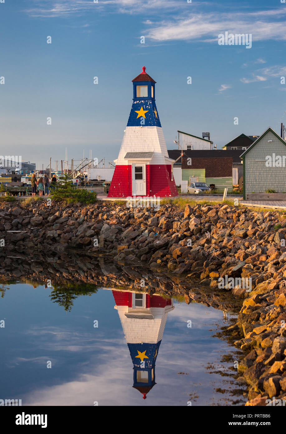 Chéticamp, Nouvelle-Écosse, Canada - le phare et la réflexion à Chéticamp Harbour, sur l'île du Cap-Breton. Banque D'Images