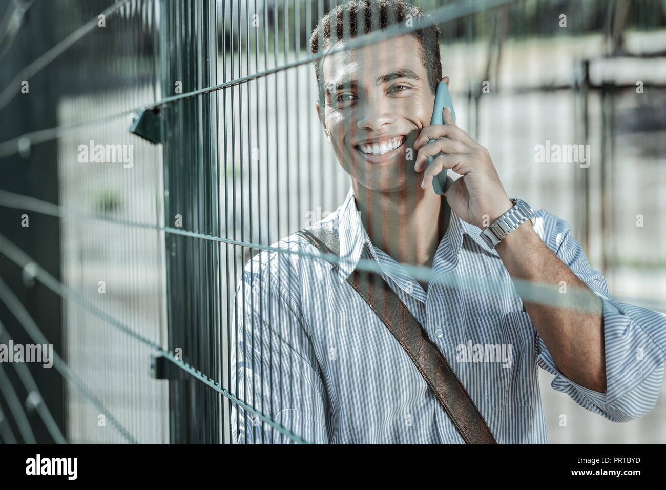 Joyeuse exubérante guy commérer sur le téléphone de façon éclatante Banque D'Images