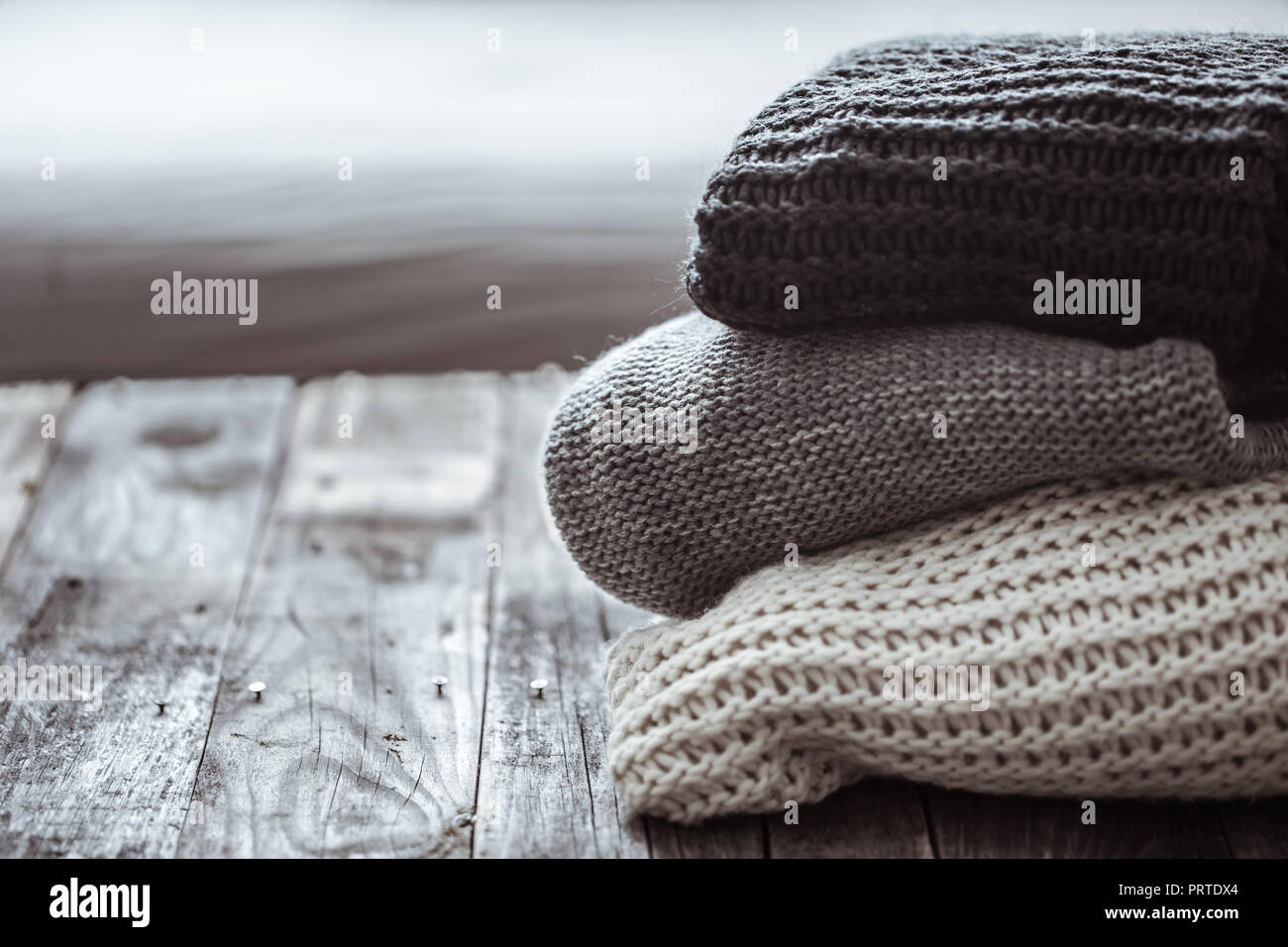 Pile de pulls confortables sur fond de bois. Concept L'automne-hiver Banque D'Images