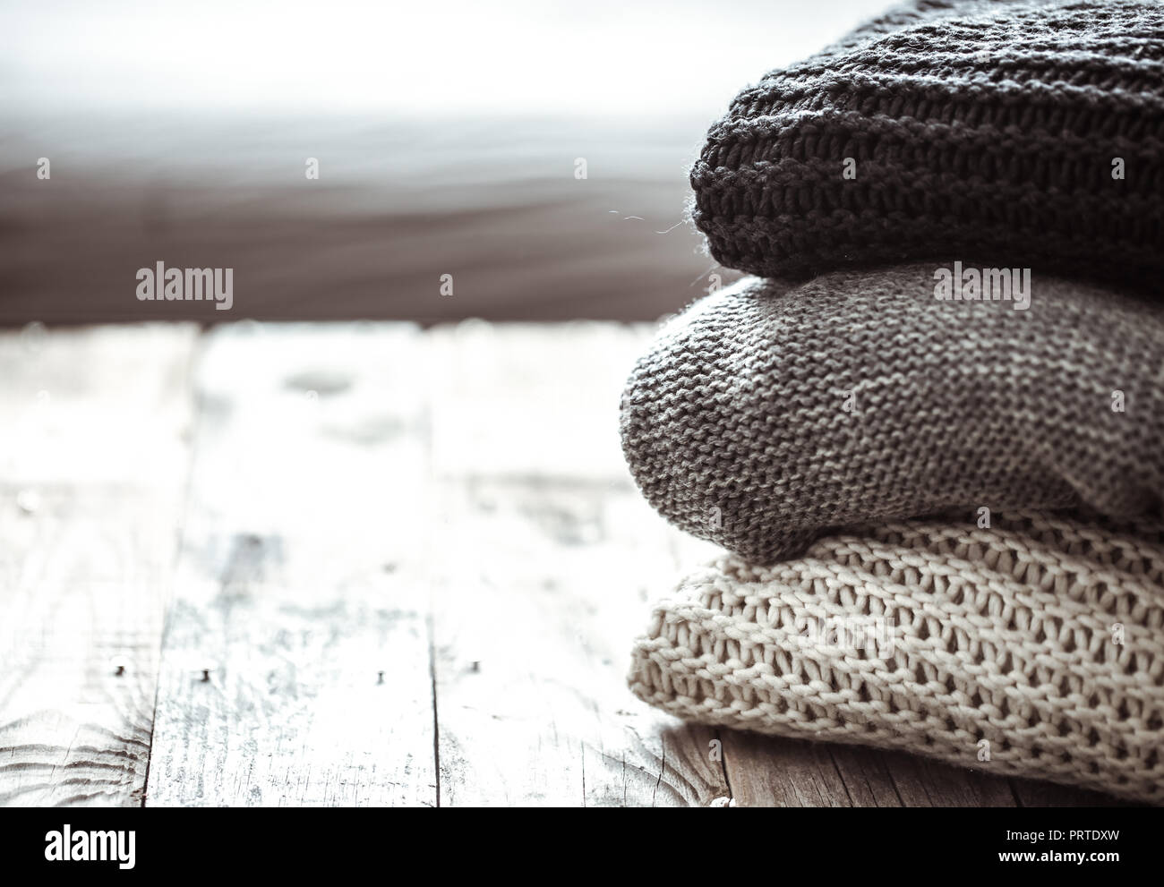 Pile de pulls confortables sur fond de bois. Concept L'automne-hiver Banque D'Images