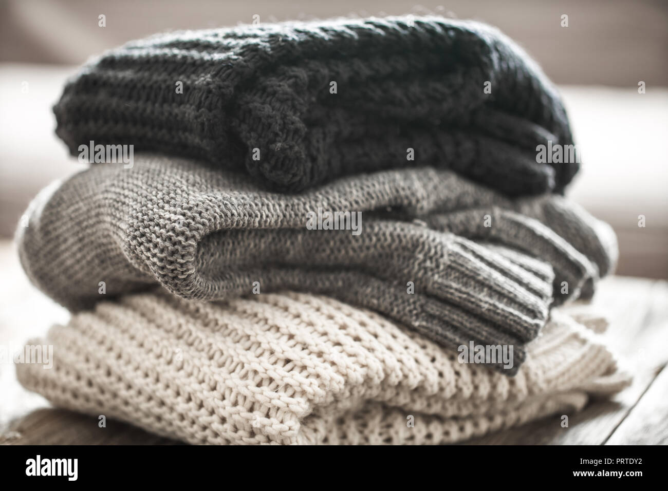 Pile de pulls confortables sur fond de bois. Concept L'automne-hiver Banque D'Images