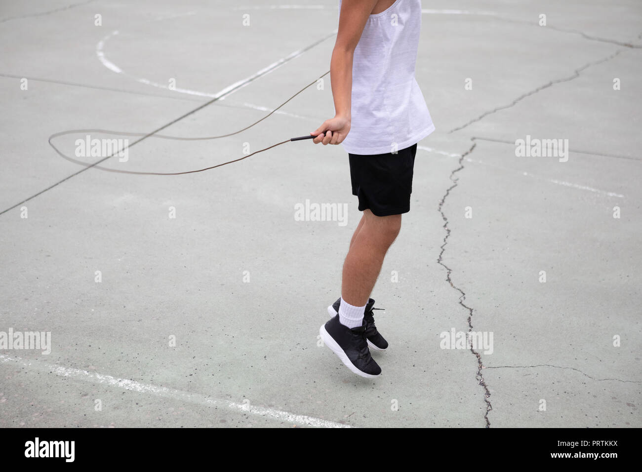 Les adolescents de sexe masculin de basket-ball sur un terrain de basket-ball, le saut vers le bas du cou Banque D'Images