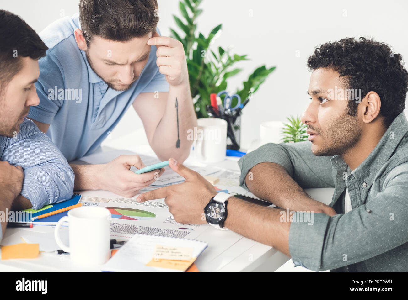 Trois jeunes hommes assis à table et de travailler sur de nouveaux projet, d'équipe business concept Banque D'Images