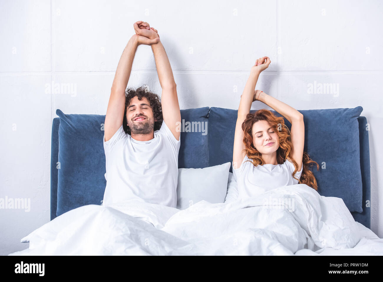 Beautiful happy young couple Waking up together in bed Banque D'Images